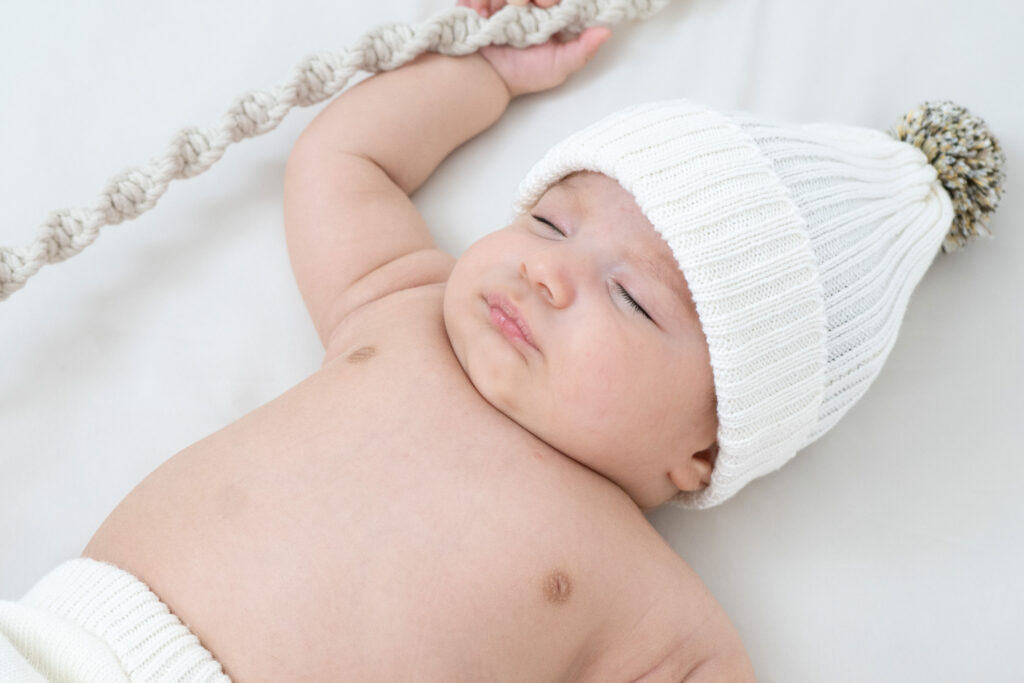 Bebé con gorro blanco en sesión de fotos – Incubox Fotografía Cali